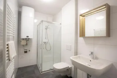 a white bathroom with a sink and a shower at Apartment Bistra Kranjska Gora in Kranjska Gora
