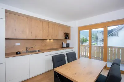 a kitchen with a wooden table and a dining room at Apartment Bistra Kranjska Gora in Kranjska Gora