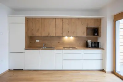 a kitchen with white cabinets and a sink at Apartment Bistra Kranjska Gora in Kranjska Gora