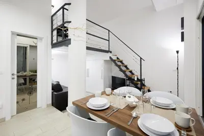 a dining room with a table and chairs and a staircase at Apartments Smreka Kranjska Gora in Kranjska Gora
