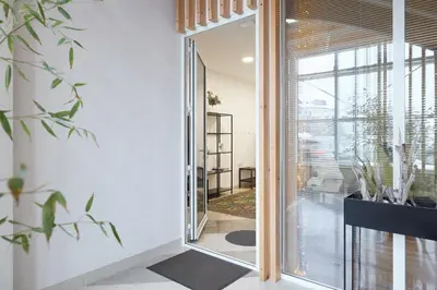 a glass door leading into a room with a mirror at Apartments Smreka Kranjska Gora in Kranjska Gora