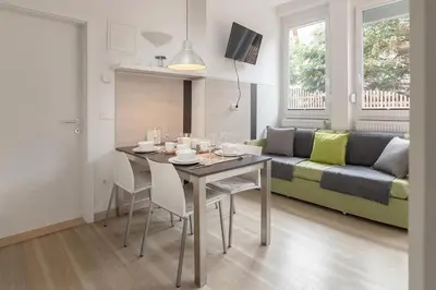 a dining room and living room with a table and a couch at Apartments Smreka Kranjska Gora in Kranjska Gora