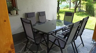 a glass table and chairs on a patio at APARTMA BRDO BC in Bovec