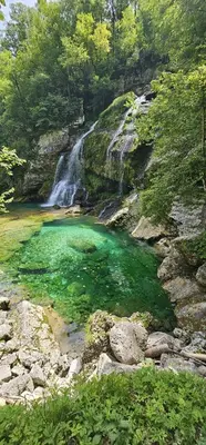 a pool of green water next to a waterfall at APARTMA BRDO BC in Bovec