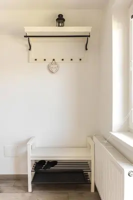 a white room with a shelf and a radiator at Pod Koblo Bohinj Apartments in Bohinj