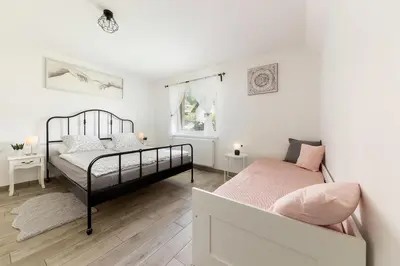a bedroom with two beds and a couch at Pod Koblo Bohinj Apartments in Bohinj