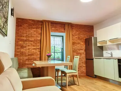 a kitchen and living room with a table and chairs at Hiša Wambrechtsamer - House Wambrechtsamer in Planina pri Sevnici