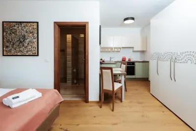 a room with a bed and a kitchen with a table at Hiša Wambrechtsamer - House Wambrechtsamer in Planina pri Sevnici