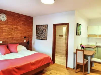 a bedroom with a bed and a desk and a kitchen at Hiša Wambrechtsamer - House Wambrechtsamer in Planina pri Sevnici