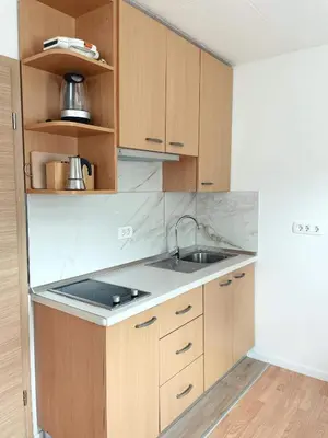 a kitchen with wooden cabinets and a sink at Apartma Kati in Bovec