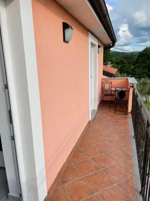 a balcony of a house with a table and chairs at Apartma Mija-Dekani in Dekani