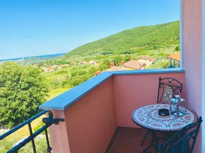 a small table on a balcony with a view at Apartma Mija-Dekani in Dekani