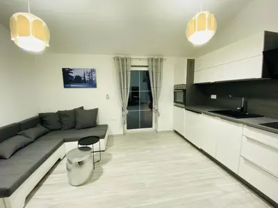 a living room with a couch and a kitchen at Apartma Mija-Dekani in Dekani