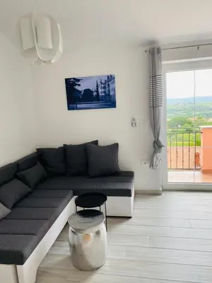 a living room with a couch and a stool at Apartma Mija-Dekani in Dekani
