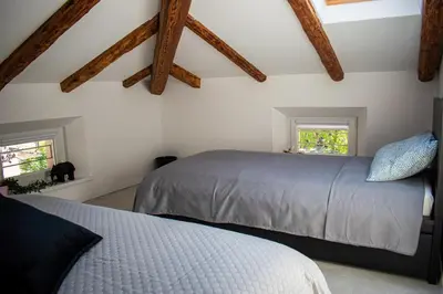 a bedroom with two beds and two windows at Apartmaji na placu in Renče