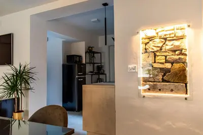 a kitchen with a wall with a stone wall at Apartmaji na placu in Renče
