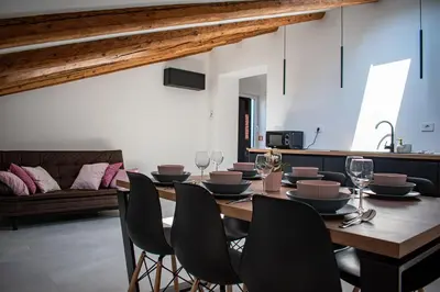 a dining room with a wooden table and chairs at Apartmaji na placu in Renče