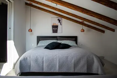 a bedroom with a bed in a room with wooden beams at Apartmaji na placu in Renče