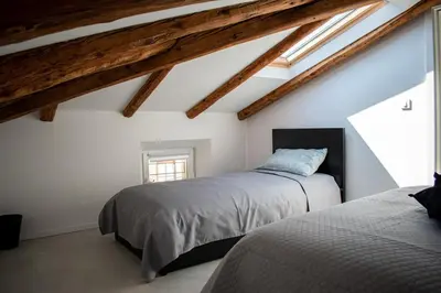 a attic bedroom with two beds and a window at Apartmaji na placu in Renče