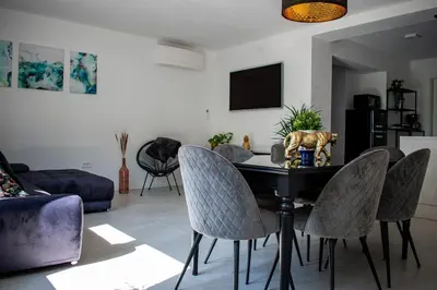 a living room with a table with chairs and a tv at Apartmaji na placu in Renče