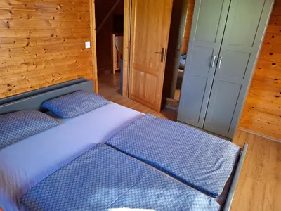 a bed with two pillows in a room at Logarska koča in Fokovci