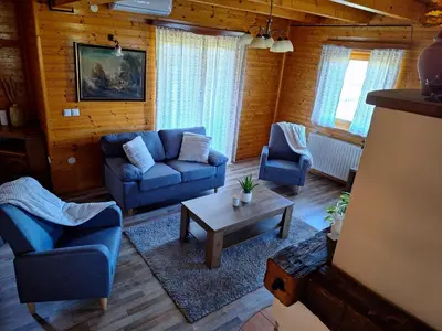 a living room with blue couches and a coffee table at Logarska koča in Fokovci
