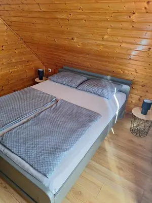 a bedroom with a bed in a wooden wall at Logarska koča in Fokovci