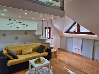 a living room with a couch and a staircase at Juliana Apartment Bohinj Lake in Bohinj