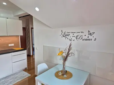 a kitchen with a table with a vase with flowers at Juliana Apartment Bohinj Lake in Bohinj