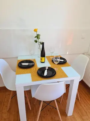 a white table with chairs and a bottle of wine at Juliana Apartment Bohinj Lake in Bohinj