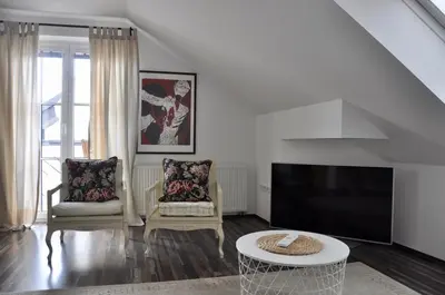 a living room with a tv and two chairs and a table at Appartment Pri Nacu in Bled