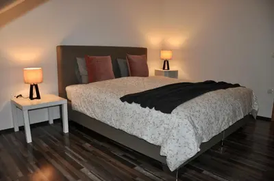 a bedroom with a bed with two lamps on two tables at Appartment Pri Nacu in Bled