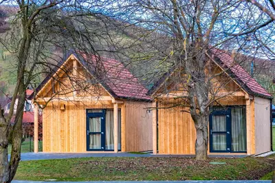 a wooden house with a red roof at Počitniške hiške Murania in Trimlini