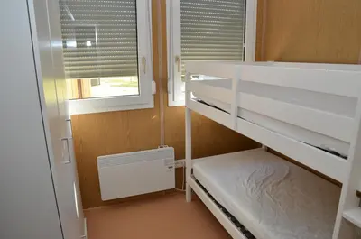 a small room with two bunk beds and a window at Počitniške hiške Murania in Trimlini