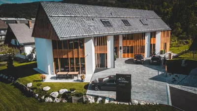 a house with a car parked in front of it at Hiša Križaj in Bohinj