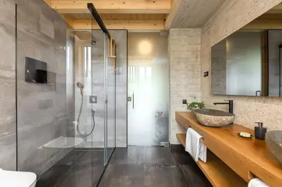 a bathroom with a glass shower and a sink at Hiša Križaj in Bohinj