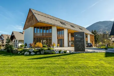 a large building with a sign in front of it at Hiša Križaj in Bohinj