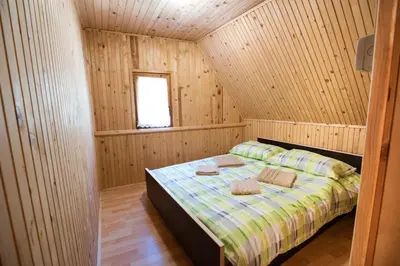 a bedroom with a bed in a wooden cabin at Mountain heart holiday house in Trenta