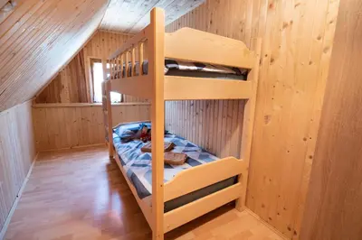 a bunk bed in a room with wooden walls at Mountain heart holiday house in Trenta