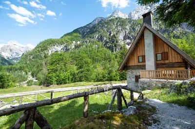 a cabin in the mountains with mountains in the background at Mountain heart holiday house in Trenta