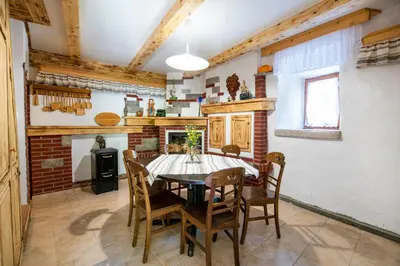 a kitchen with a dining room table and chairs at Mountain heart holiday house in Trenta