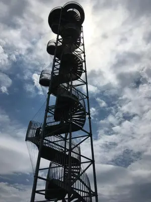 a metal spiral tower with manyousandcycles on it at Hiška Marjetica in Podčetrtek