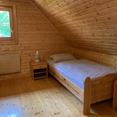 a bedroom with a bed in a wooden cabin at Hiška Marjetica in Podčetrtek