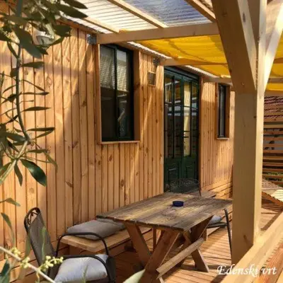 a wooden deck with a wooden table and chairs at Edenski vrt in Ivančna Gorica