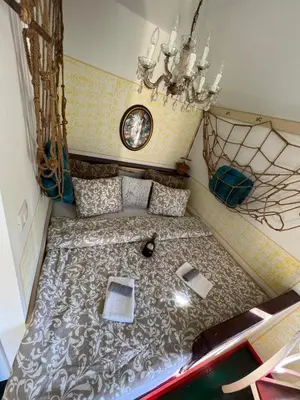 a large bed in a small room with a chandelier at Edenski vrt in Ivančna Gorica