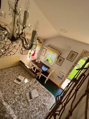 a room with a bed and a table and a chandelier at Edenski vrt in Ivančna Gorica