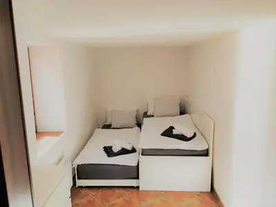 a small room with two beds and a mirror at Natur pur Pikovo in Črna na Koroškem