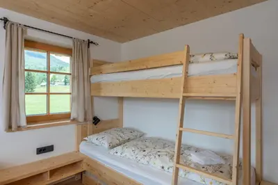 two bunk beds in a room with a window at Planinska koča na Uskovnici in Srednja Vas v Bohinju