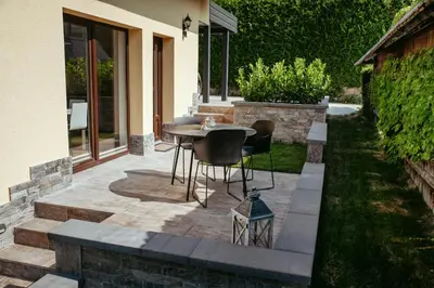 a patio with a table and chairs in a yard at Apartment Oddih with terrace and private SAUNA in Bled