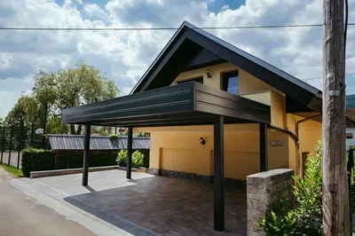a detached house with a black roof at Apartment Oddih with terrace and private SAUNA in Bled